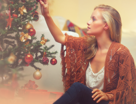 girl hanging decorations on christmas tree